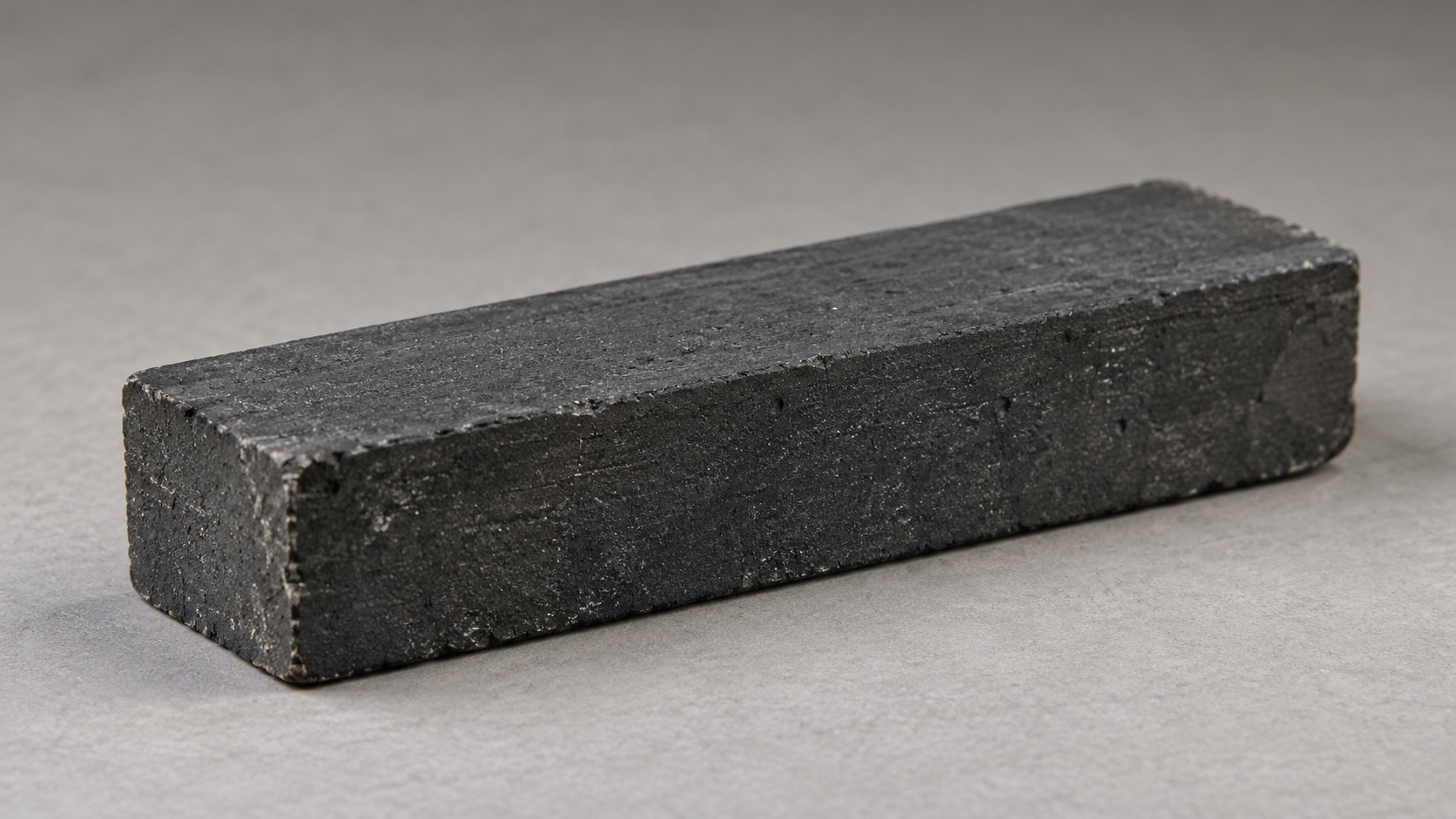 Historical reconstruction of a dark rectangular graphite block, representing material used in Chicago Pile-1.
