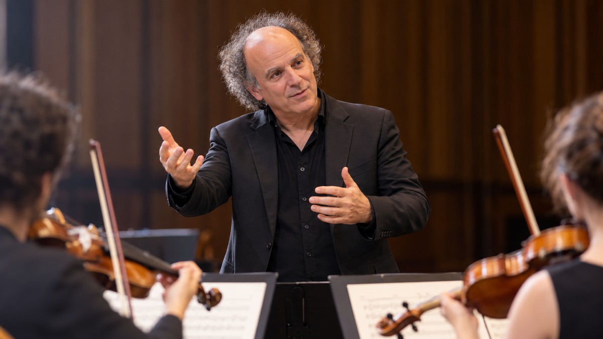 AI-generated editorial portrait of Itay Talgam conducting a chamber ensemble while inviting visible musician autonomy
