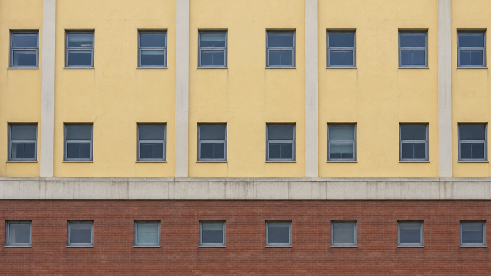 AI historical reconstruction of the yellow facade, pale vertical ribs and red masonry band of Pyeongtaek St Mary’s Hospital.