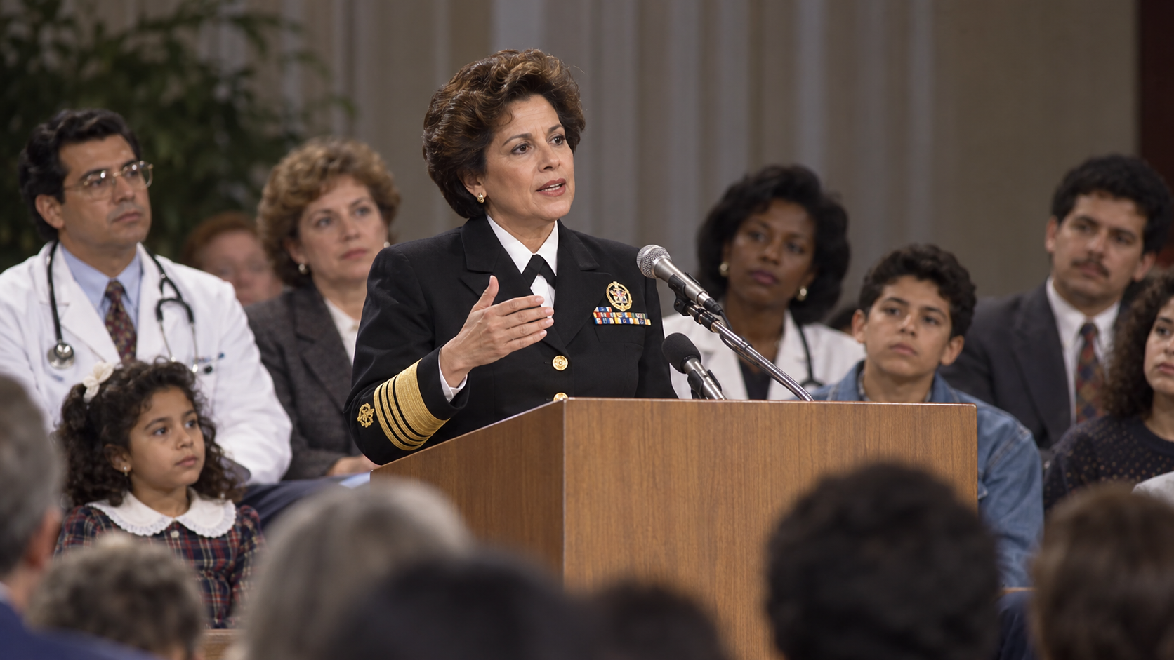 AI-generated reconstruction of Antonia Novello addressing a public-health audience; not an archival photograph.