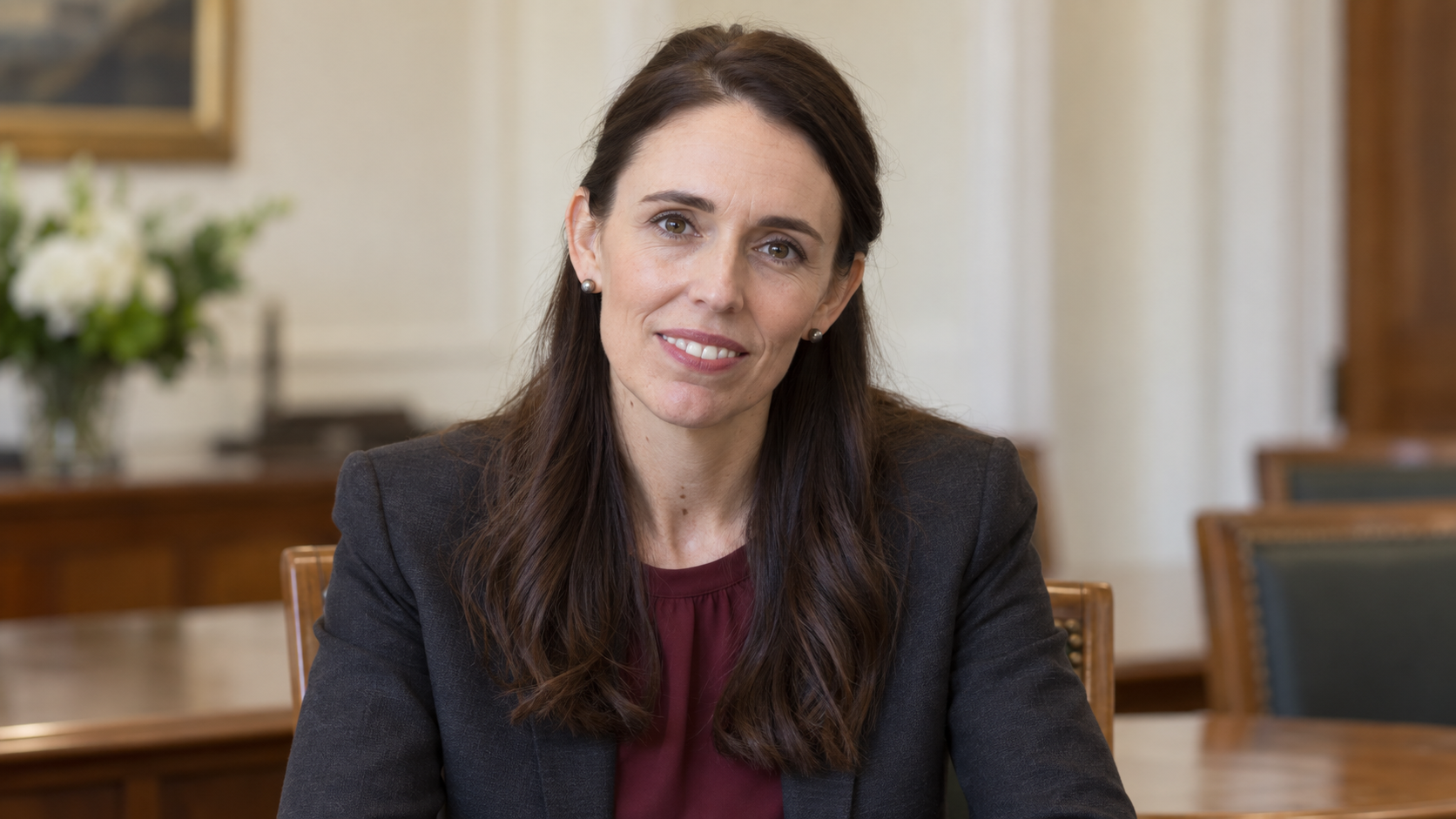 Realistic editorial recreation of Jacinda Ardern in a quiet New Zealand civic meeting room in 2019.