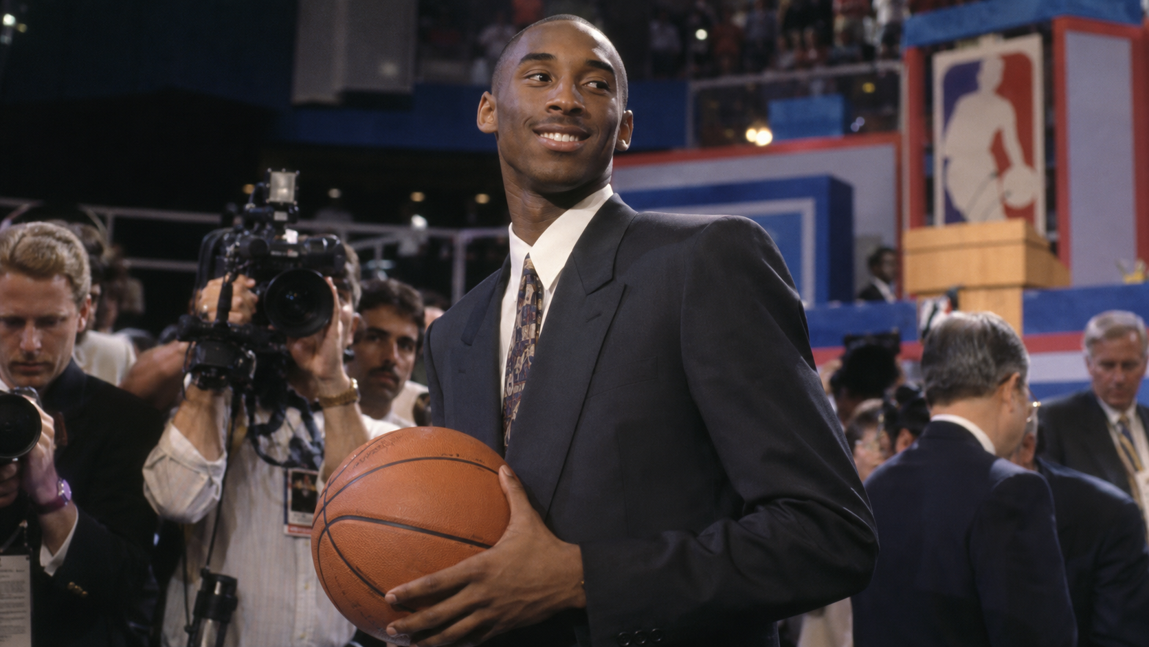 Photorealistic historical reconstruction of teenage Kobe Bryant holding a basketball on the night of the 1996 NBA Draft.