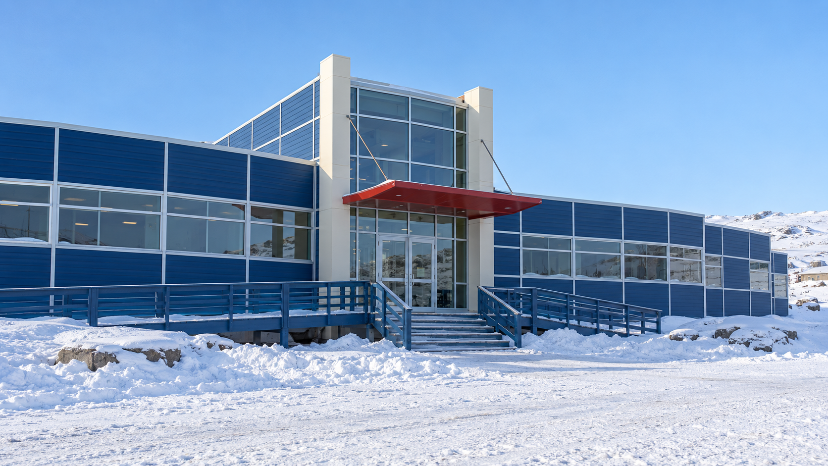 Historical reconstruction of the blue-clad entrance to Nunavut’s Legislative Assembly in snowy Iqaluit around 1999.