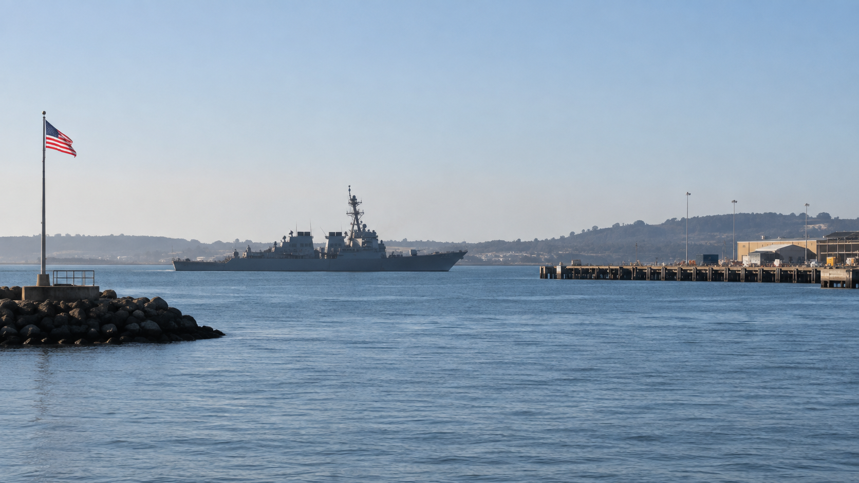 A navy vessel distant on calm water.