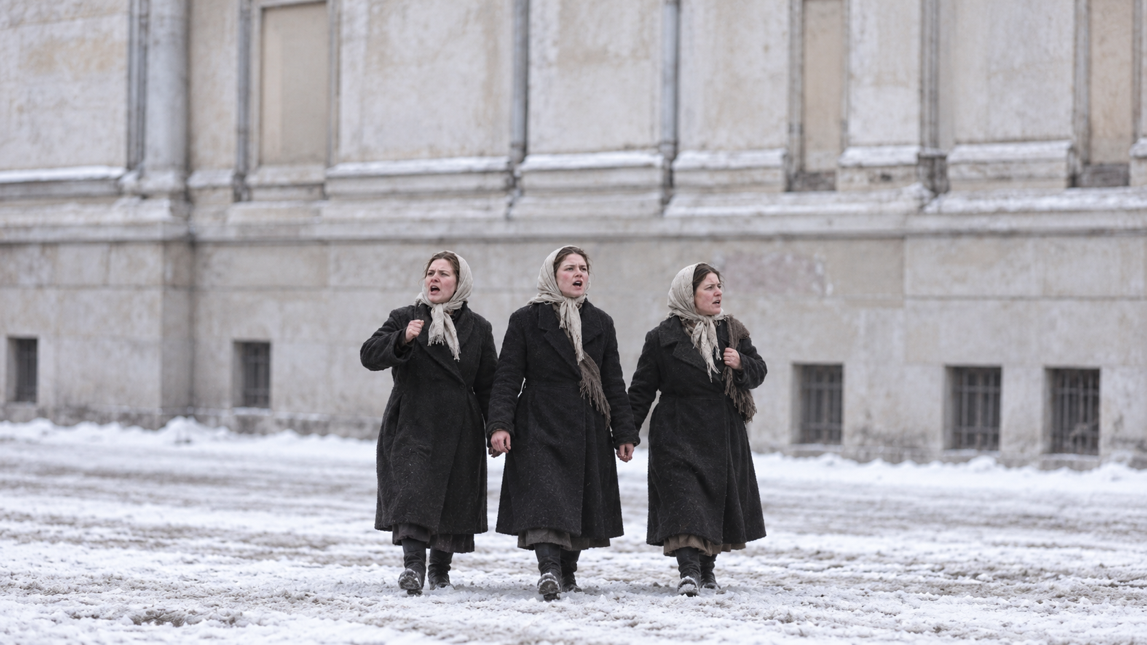 Historical reconstruction of women workers in coats and headscarves in Petrograd in 1917.