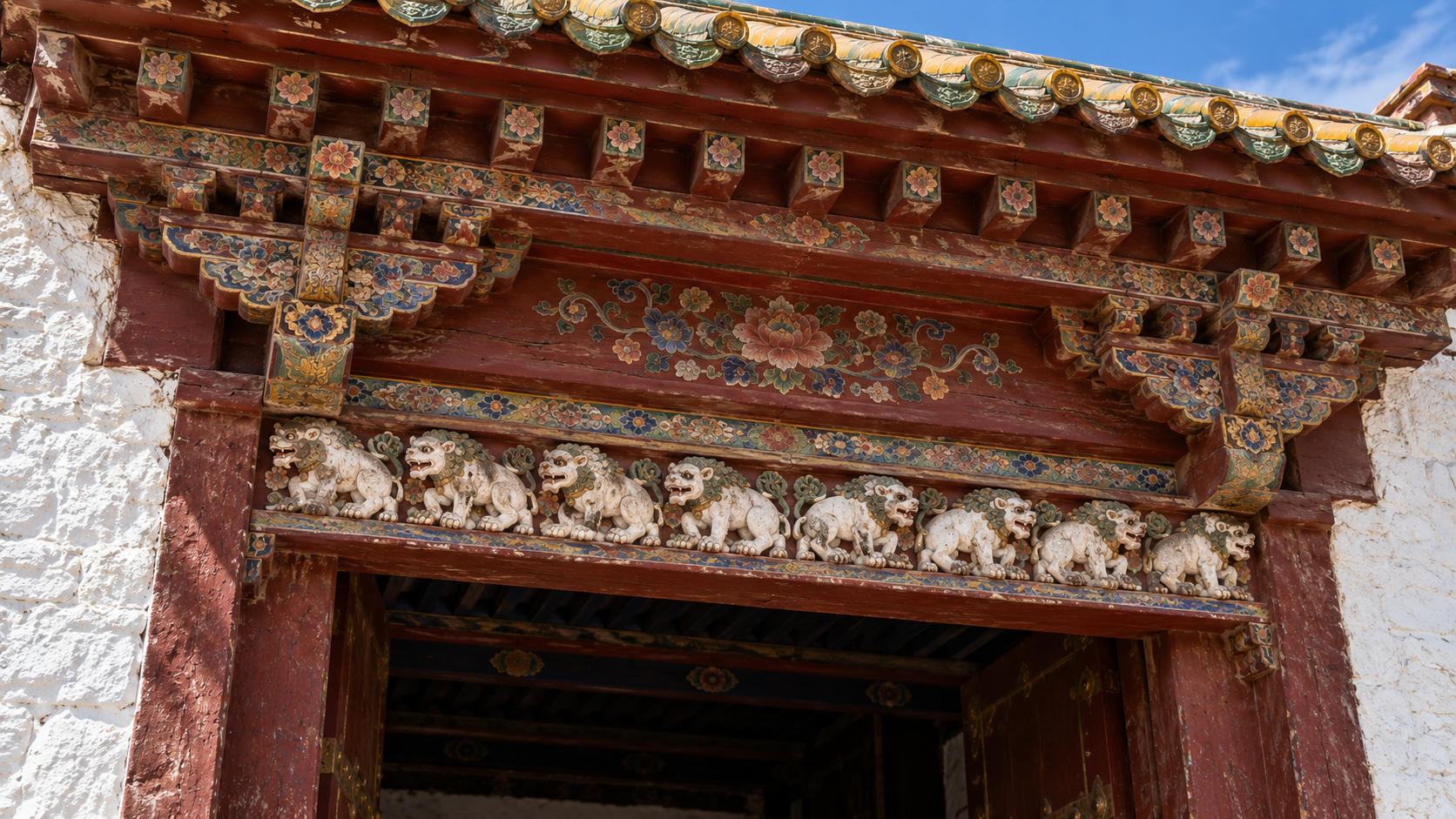 Historical reconstruction of traditional carved and painted woodwork at a Tibetan palace gate.