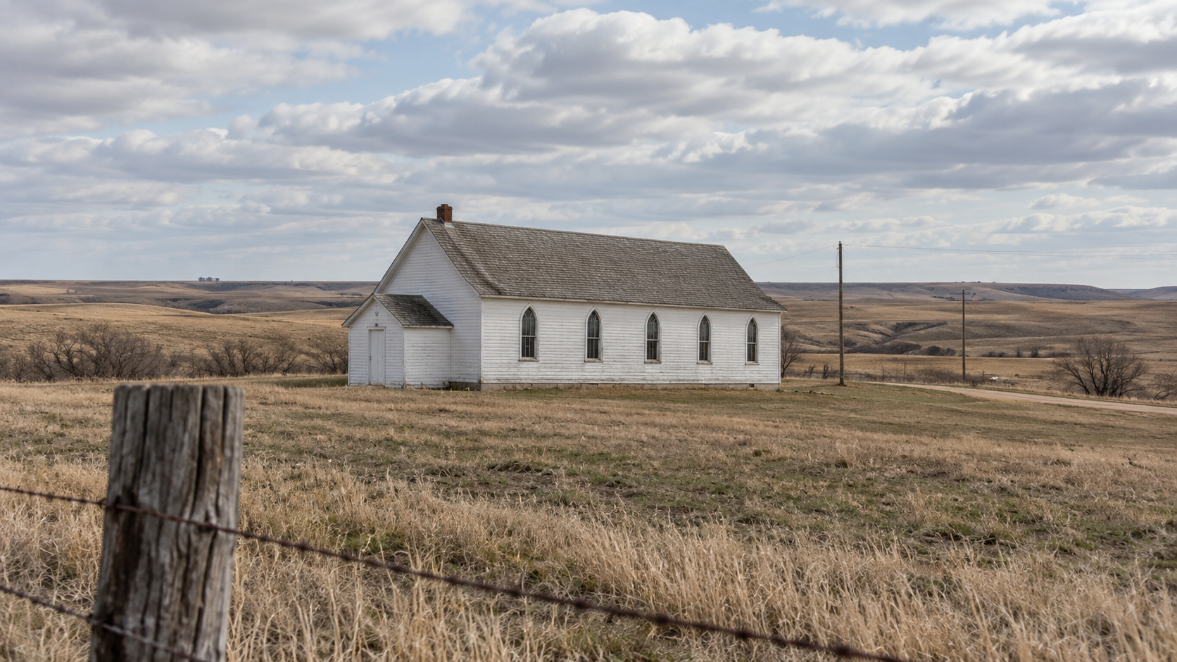 Historical reconstruction of a white wooden church and prairie landscape at Wounded Knee around 1973.