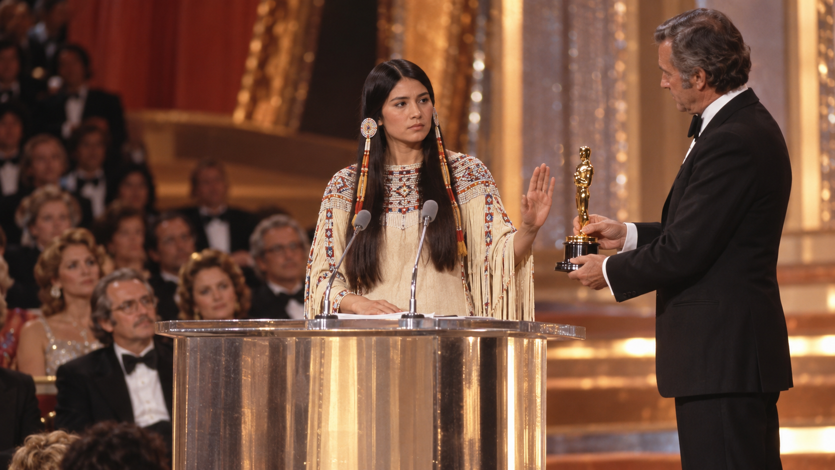 AI reconstruction: a young Indigenous activist respectfully declines an award at the 1973 Oscars podium, cinematic 16:9.
