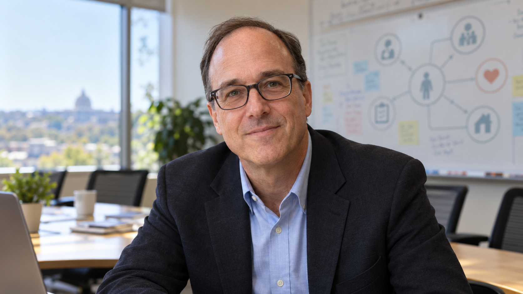Eric Dishman in a coordinated-care meeting room with a shared care plan softly blurred