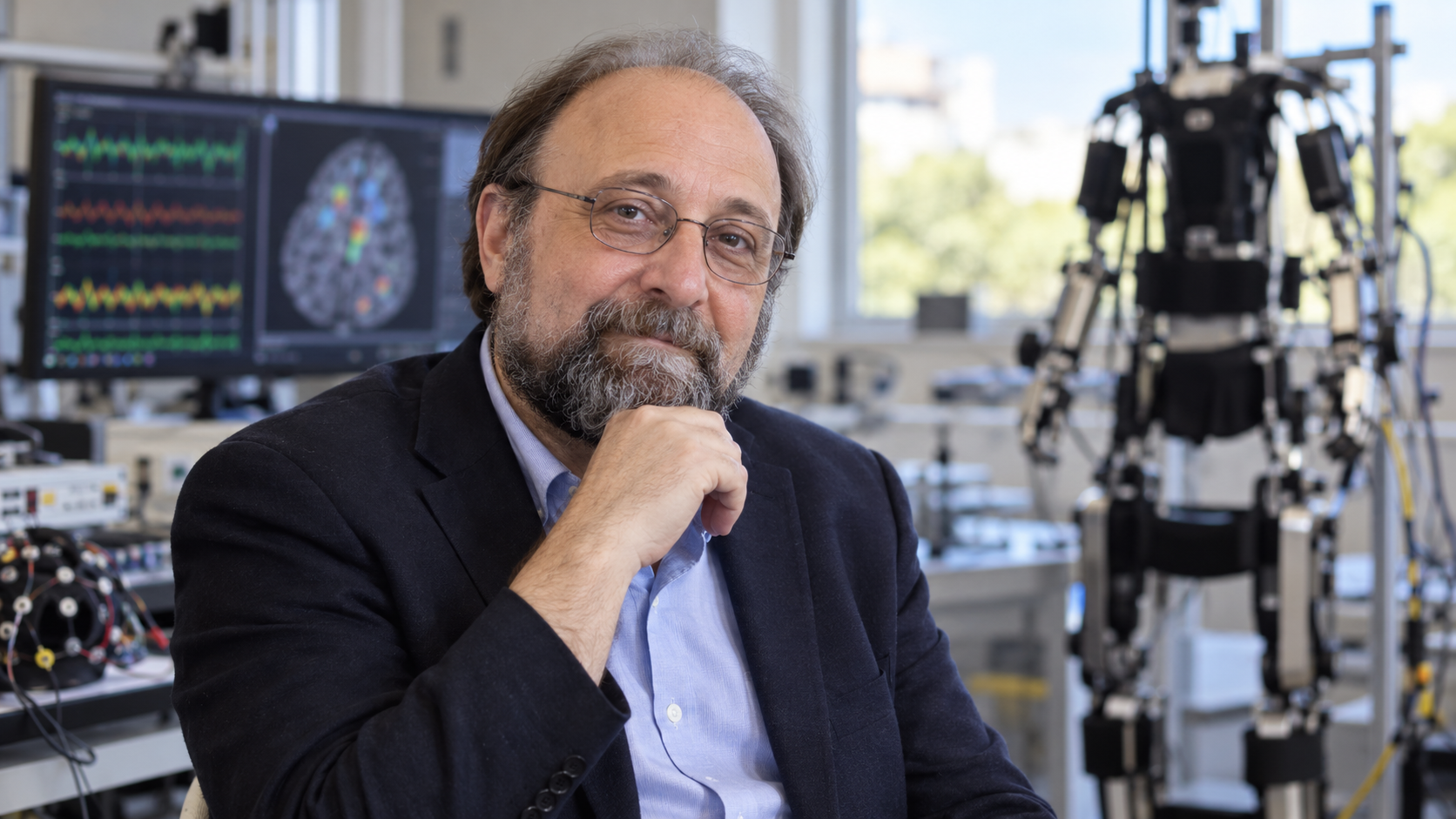 Miguel Nicolelis in a neuroscience laboratory with an exoskeleton and neural signals softly blurred
