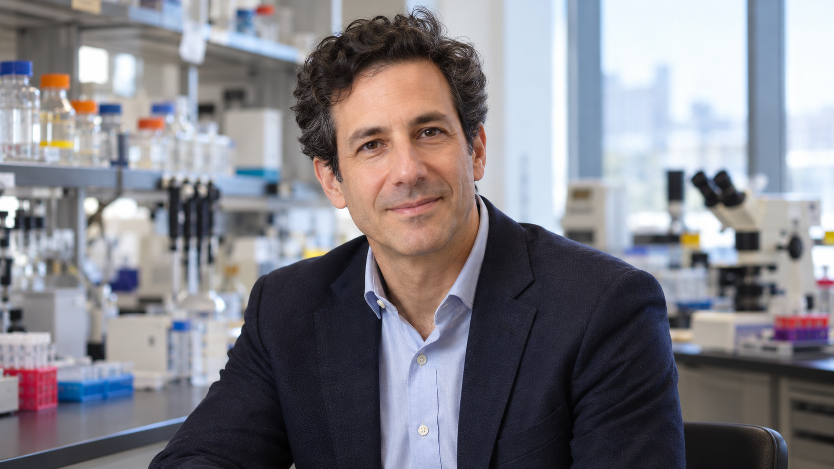 Ofer Levy in an immunology laboratory with vaccine-response assays softly blurred